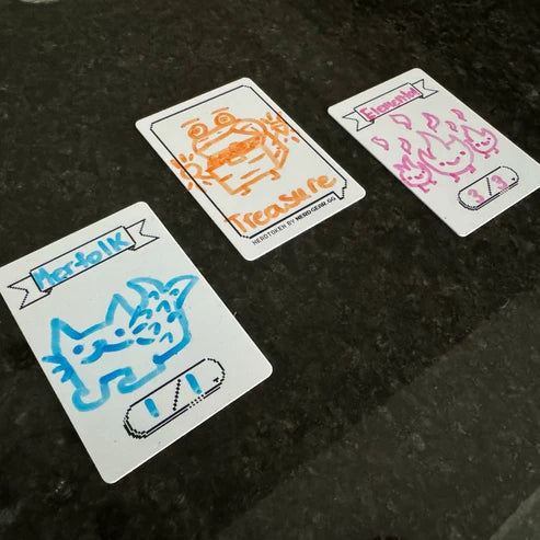 Nerd Gear NerdTokens - Extra Thick Dry Erase Tokens for MTG - 12 Pack showing hand-drawn Merfolk, Treasure, and Elemental cards on a dark surface.