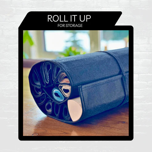 Nerd Gear Playmat Sanctuary rolled up, showcasing durable felt design with pockets for organizing Magic the Gathering playmats, secured by a strap for compact storage.